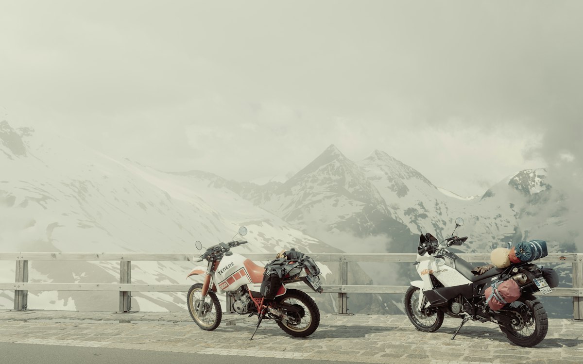 Deux motos à l'arrêt devant un panorama de montagnes enneigées