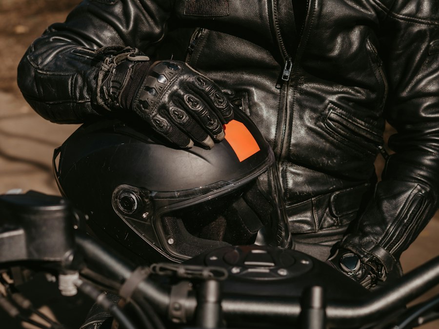 Motard en blouson de cuir tenant son casque