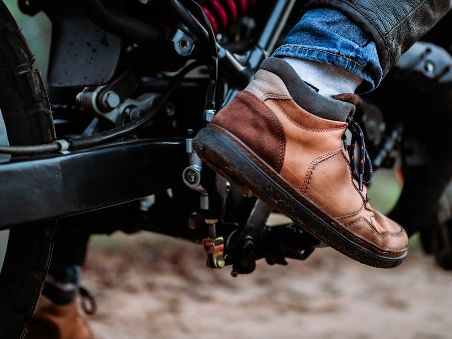 Chaussure de moto montante posée sur le repose-pied d'une moto