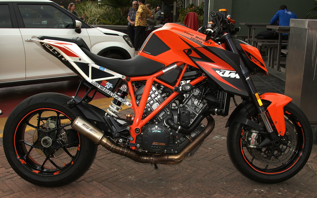 Roadster orange et noir de grosse cylindrée stationné en ville
