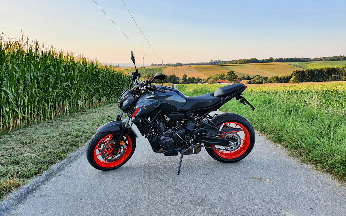 Roadster de moyenne cylindrée stationné sur une route de campagne